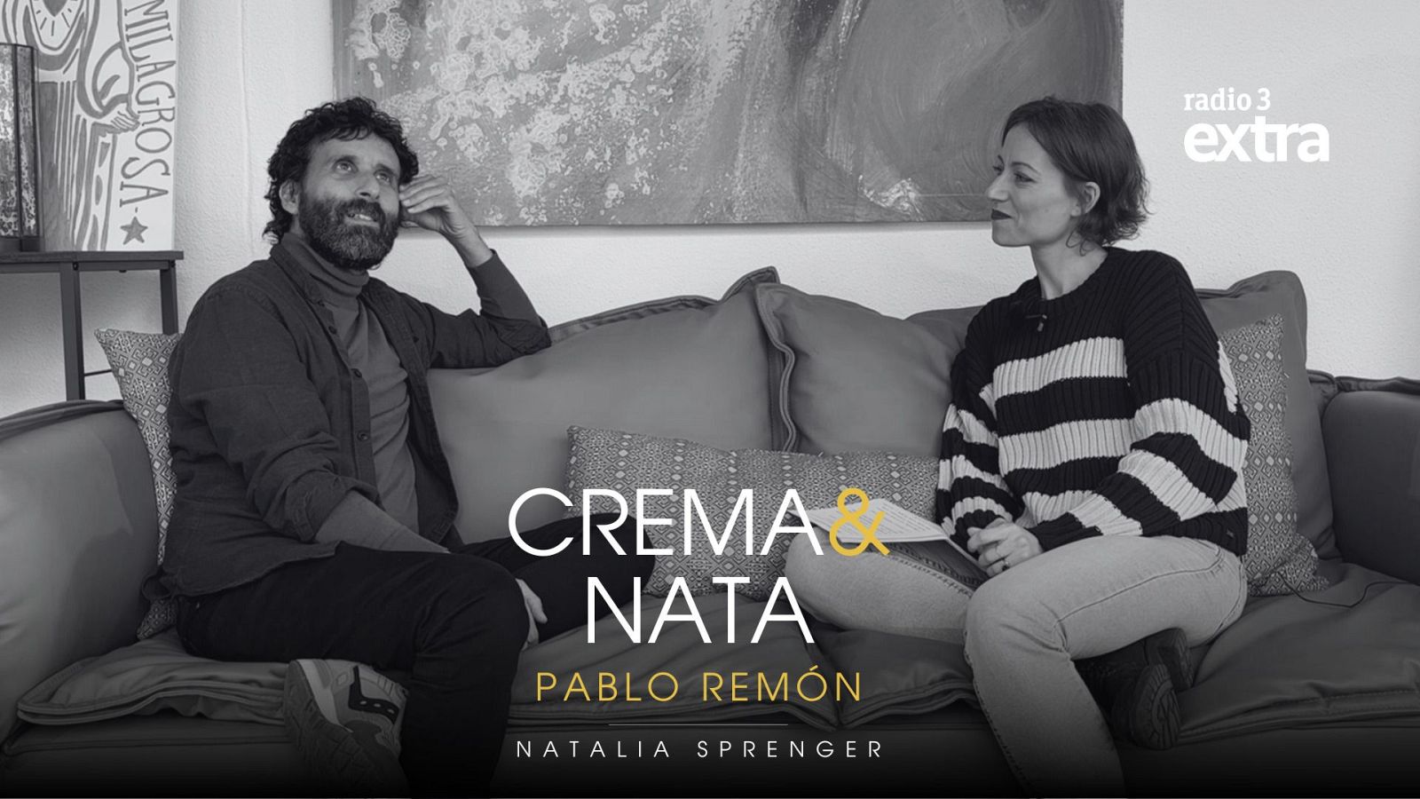 Una imagen muestra a Pablo Remón y Natalia Sprenger sentados en un sofá. El hombre, con barba y jersey oscuro, mira hacia un lado, mientras que la mujer, con un jersey a rayas, le observa. El título "CREMA & NATA" y los nombres aparecen en la parte inferior.