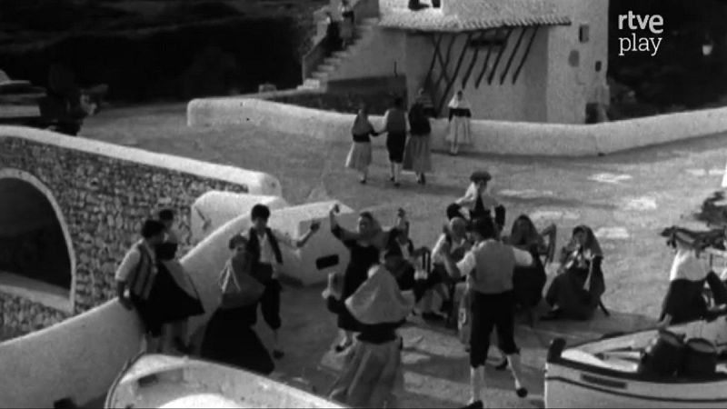 Archivo de RTVE Play: "Paisanos" de Menorca en un pueblo tradicional, con vestimenta típica y celebrando en comunidad.