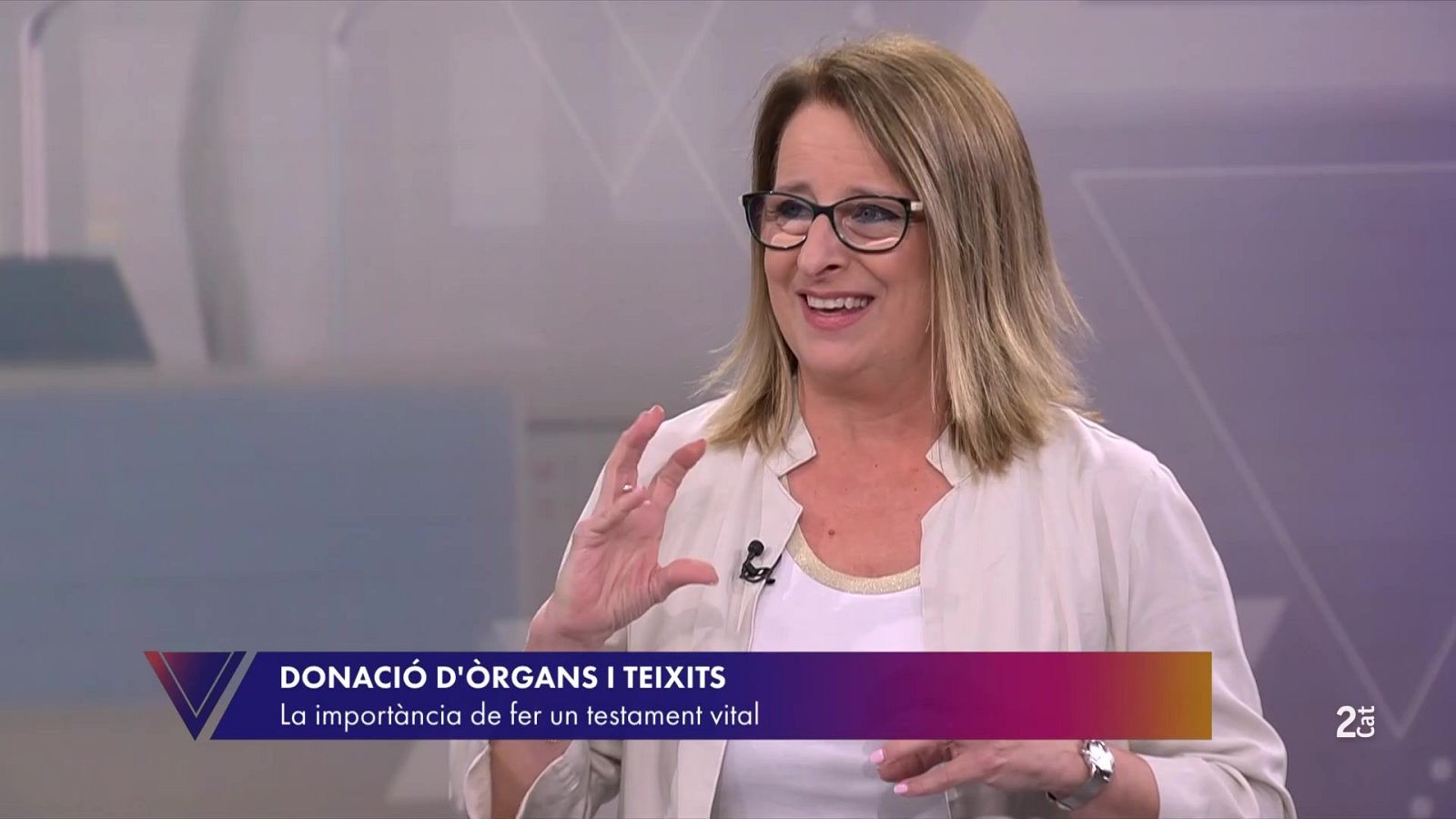 Helena Garcia Melero, presentadora, sonríe y gesticula en el estudio de "El Vespre". Banner: "DONACIÓ D'ÒRGANS I TEIXITS" y "La importància de fer un testament vital".