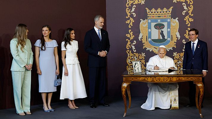 El Papa Francisco firma un libro de honor en un evento oficial, flanqueado por la Familia Real Española y el Alcalde de Madrid, José Luis Martínez-Almeida.
