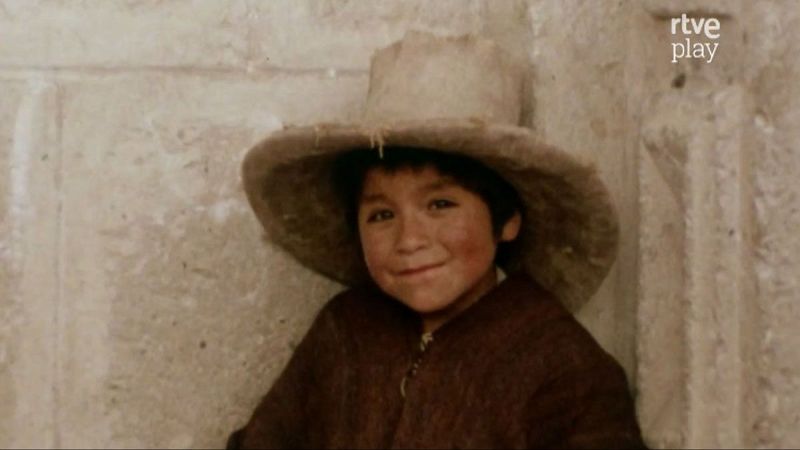 Ni�o de rasgos andinos, con sombrero y abrigo oscuro, sonr�e inocentemente a c�mara. Fondo de pared r�stica. Logo "rtve play" visible.