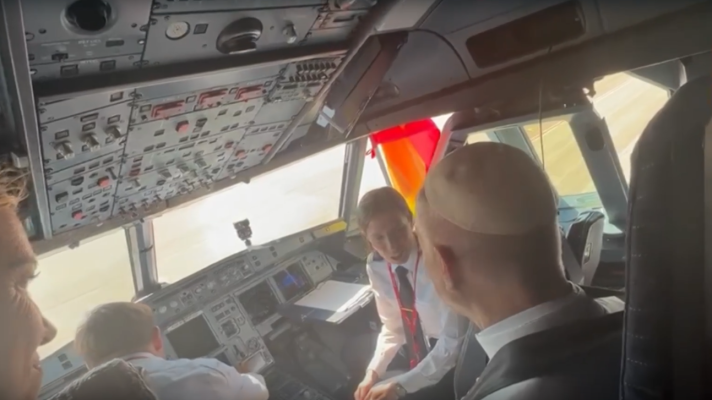 El Papa Francisco en la cabina de un avión, junto a la tripulación. Se aprecian paneles de control, ventanas con cielo despejado y una bandera de España.