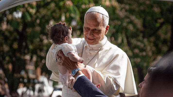 El Papa León XIV bendice un bebé en el Papamóvil, de camino al Movistar Arena