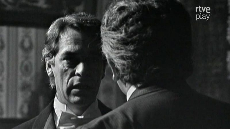 Primer plano de José Bódalo en blanco y negro, con expresión seria, junto a otro hombre de espaldas. Logo "rtve play" en la esquina superior derecha.