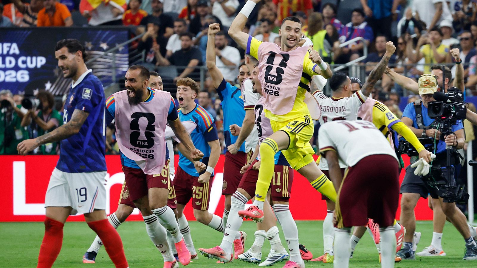 Jugadores celebran en un campo de fútbol, con Theo Hernández, Dani Carvajal, Gavi, Kepa Arrizabalaga y Ferran Torres en acción. Se distingue el logo y texto de la FIFA World Cup 2026.