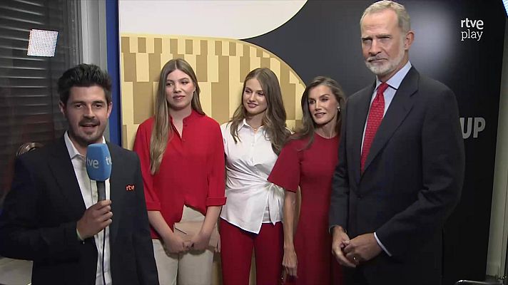 Familia Real Española (Rey Felipe VI, Reina Letizia, Princesa Leonor, Infanta Sofía) y reportero de RTVE posan en un evento. Fondo con logo RTVE Play.