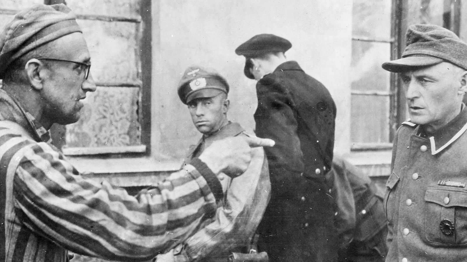 Un prisionero del campo de concentración de Dachau señala a un guardia nazi