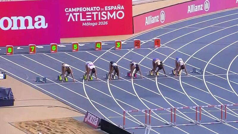 Atletas femeninas en posición de salida en pista azul para carrera de vallas. "Joma", "Allianz" y "CAMPEONATO DE ESPAÑA DE ATLETISMO Málaga 2026" visibles en vallas publicitarias.