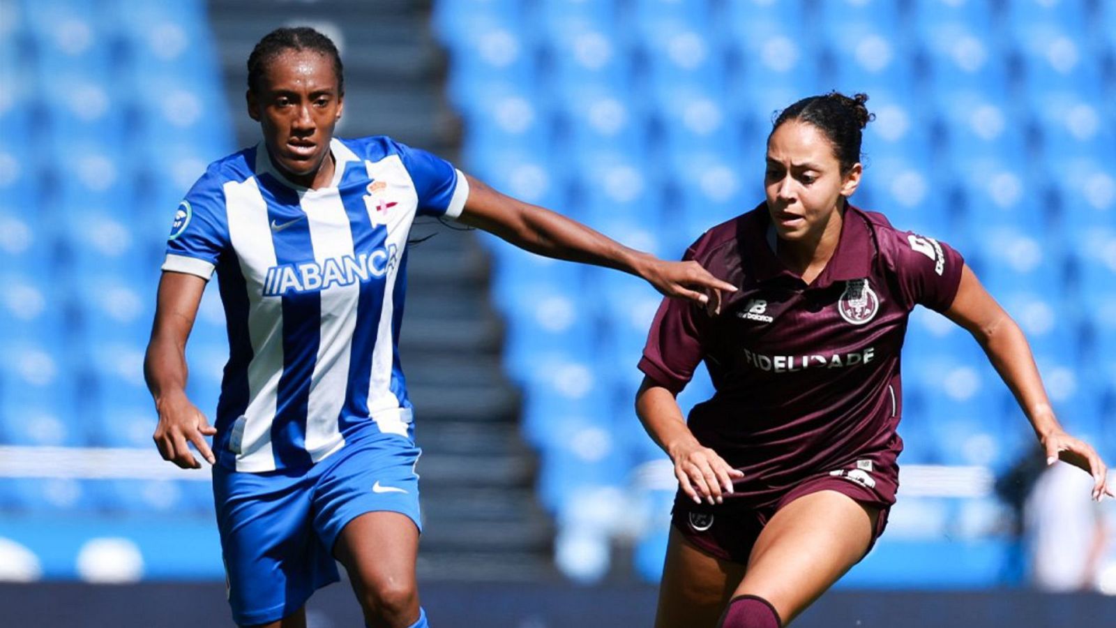 Carlota Suárez (Deportivo Abanca) y Ana Capeta (Sporting CP) compiten por el balón en un partido de fútbol. "ABANCA" y "FIDELIDADE" son visibles en sus camisetas.