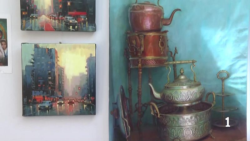Exhibición de arte en pared blanca: paisajes urbanos con reflejos y naturaleza muerta con objetos metálicos antiguos.