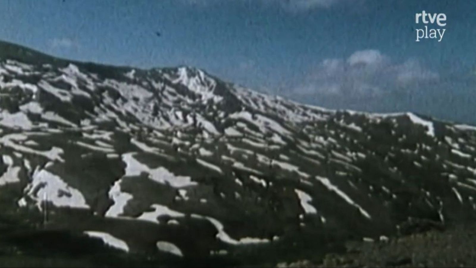 Paisaje de alta montaña de Sierra Nevada con nieve y terreno expuesto bajo cielo azul. Logo "rtve play" en la esquina superior derecha.