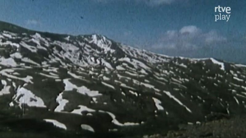 Paisaje de alta monta�a de Sierra Nevada con nieve y terreno expuesto bajo cielo azul. Logo "rtve play" en la esquina superior derecha.
