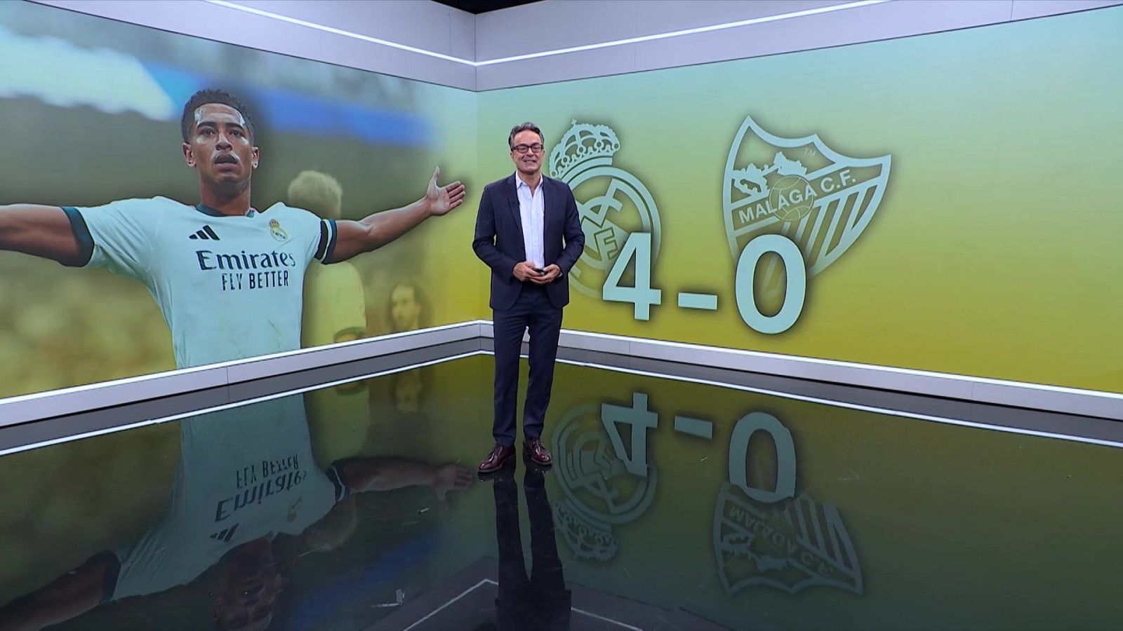 Marcos López, periodista deportivo, en un estudio con pantalla que muestra a Jude Bellingham y el resultado 4-0 a favor del Real Madrid C.F. sobre el Málaga C.F.