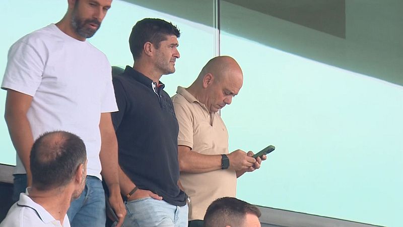 Chema Aragón, director deportivo del Racing de Santander, observa un evento en Cantabria junto a otros hombres. La escena se desarrolla en una zona de observación elevada.