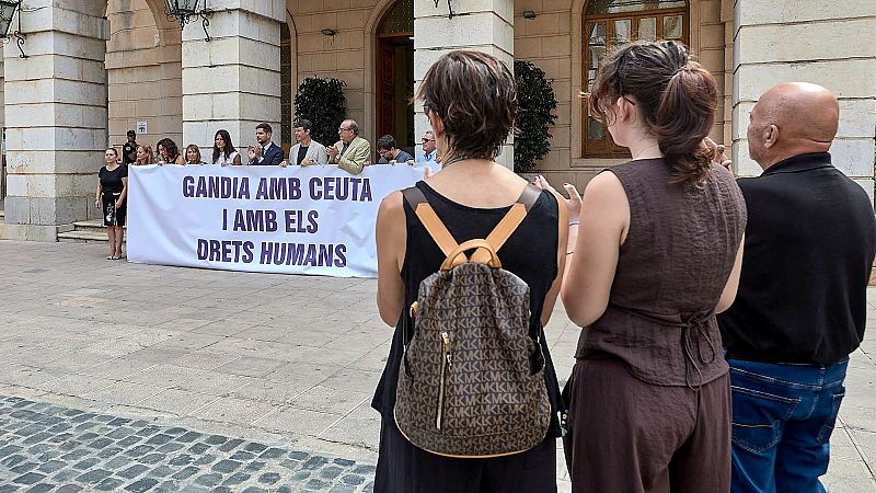José Manuel Prieto, alcalde de Gandia, preside un acto de apoyo a Ceuta y los derechos humanos frente al Ayuntamiento, con un cartel que reza "GANDIA AMB CEUTA I AMB ELS DRETS HUMANS".