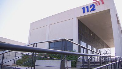Edificio de emergencias con el n�mero "112" destacado, rampa de acceso, escaleras y vegetaci�n bajo un cielo claro.