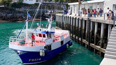 Barco pesquero "Alexandra Mar�a" llega al puerto de Llanes, Asturias, con medios de comunicaci�n y p�blico expectante en el muelle.