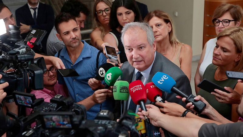 Miguel Ángel Oliver, rodeado de periodistas con micrófonos de TVE, Europa Press, Cadena SER, La Sexta y Onda Cero, en un evento de gran cobertura mediática.