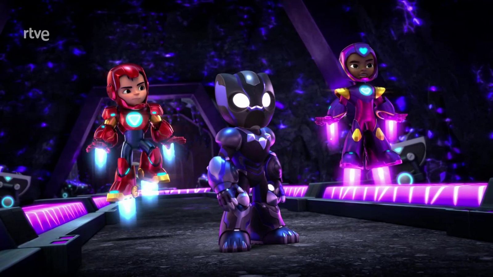 Tres superhéroes, incluyendo una versión joven de Iron Man, un personaje tipo Black Panther y una heroína púrpura, posan en una base futurista iluminada por neón púrpura. Se observa el logo 'rtve' en la esquina superior izquierda.