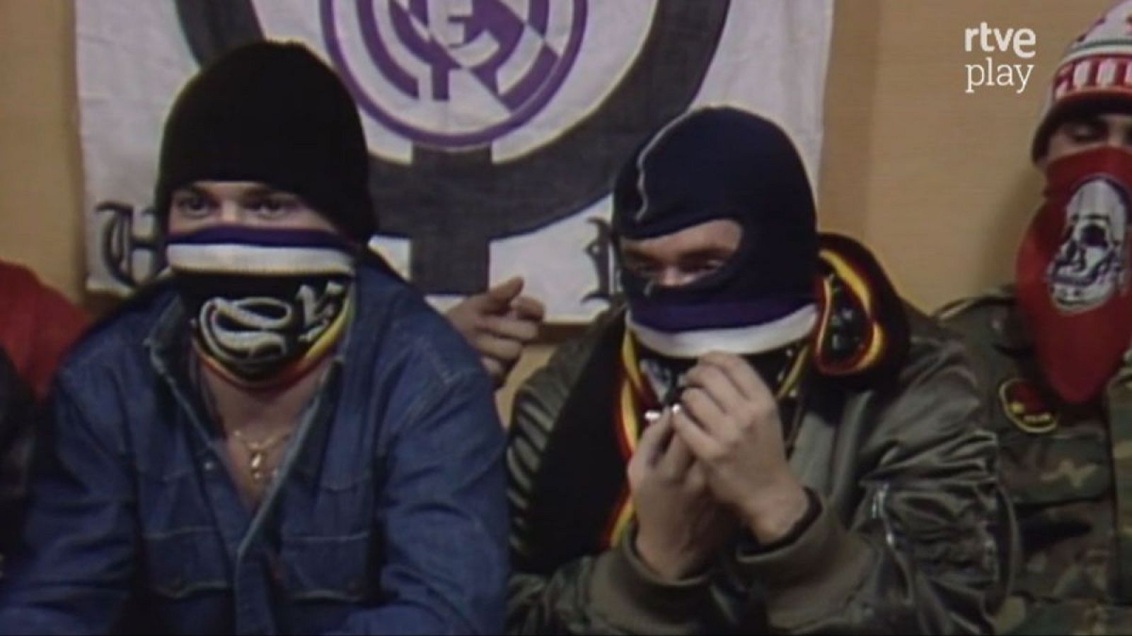 Tres hombres con rostros cubiertos por bandanas y pasamontañas, junto a una bandera del Real Madrid C.F. con el emblema "Ultras Sur" y el logo "rtve play".