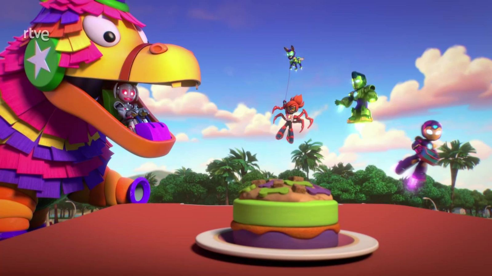 Superhéroes como Hulk, Spider-Man e Iron Man vuelan sobre un paisaje tropical con una piñata y un pastel en primer plano. Logo de RTVE en la esquina superior izquierda.