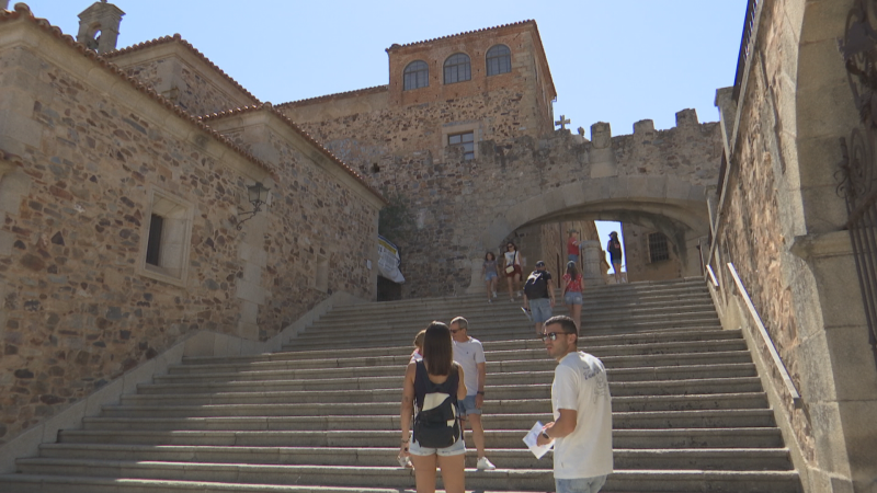 Vista ascendente de una gran escalera de piedra en un entorno urbano hist�rico, con edificios de mamposter�a a los lados y turistas explorando.