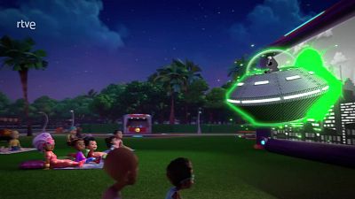 Escena nocturna de cine al aire libre con niños viendo una proyección de ciencia ficción de un UFO brillante. Logo 'rtve' visible.