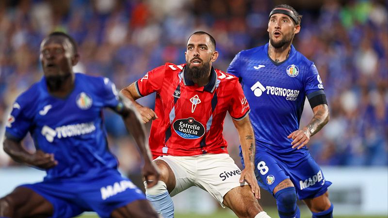Iago Aspas y Nemanja Maksimović, junto a otro jugador del Getafe, se concentran intensamente en un partido de fútbol, siguiendo la trayectoria de la acción en el aire.