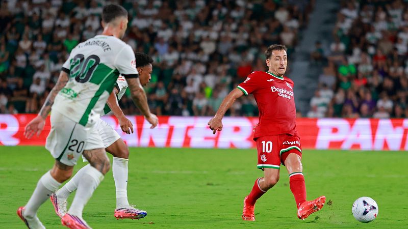 Jugador L. MORENTE (20) en acción, junto a otro jugador (10) a punto de patear el balón. Valla publicitaria "PANTER" al fondo.