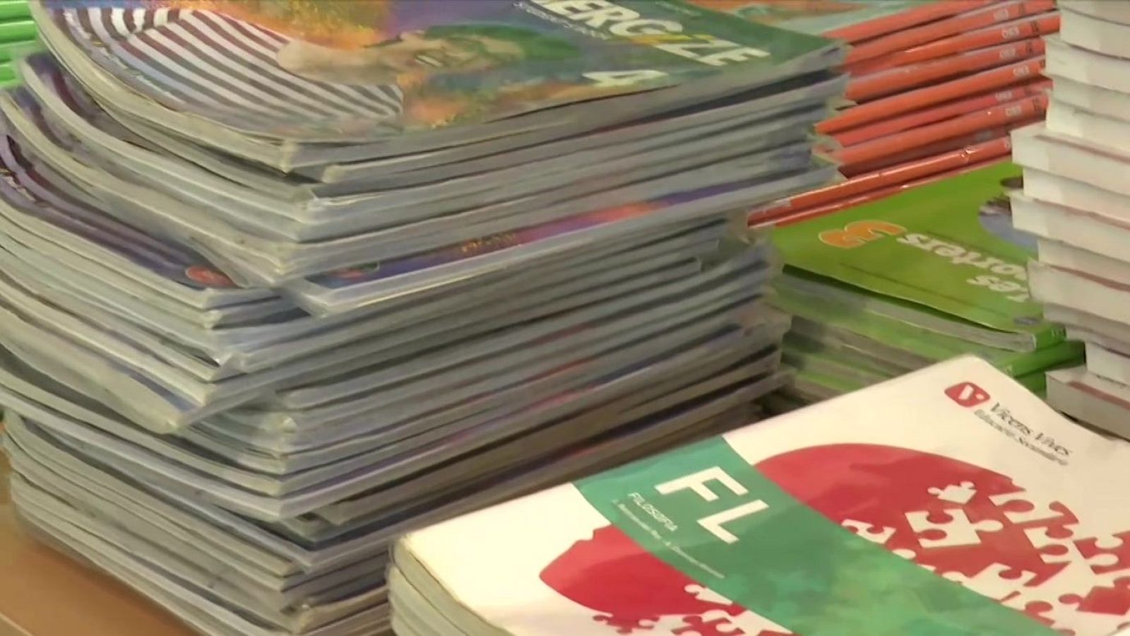 Primer plano de pilas de libros educativos, incluyendo "ENERGIZE 4" y "FILOSOFÍA" de Vicens Vives.