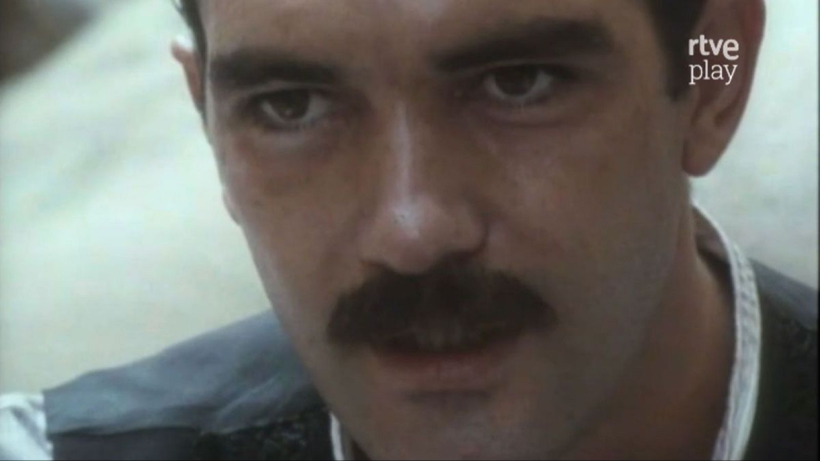 Antonio Banderas en un primer plano, con bigote y mirada seria. Se observa el logo de "rtve play".