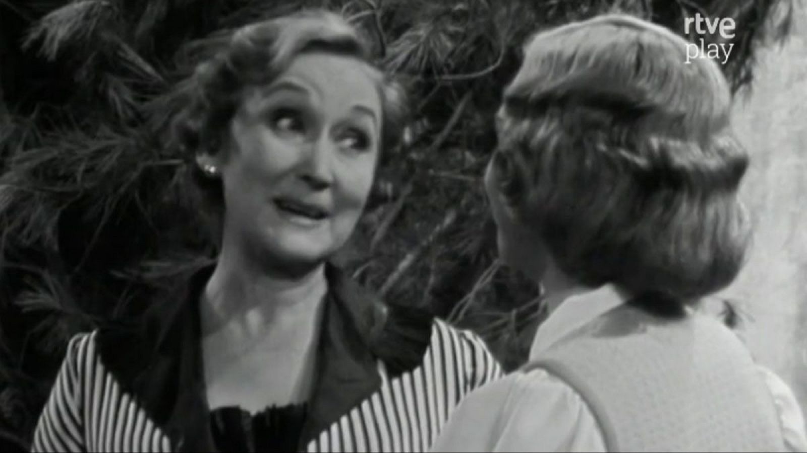 Amparo Baró en una escena dramática, mirando intensamente a otra mujer. Fondo oscuro con el logo 'rtve play'.