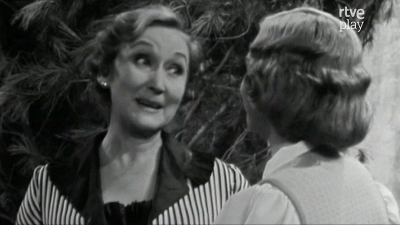 Amparo Baró en una escena dramática, mirando intensamente a otra mujer. Fondo oscuro con el logo 'rtve play'.