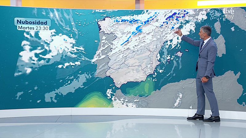 Martín Barreiro, en un estudio de TVE, presenta el pronóstico del tiempo señalando un mapa detallado de la Península Ibérica con nubosidad y precipitaciones.