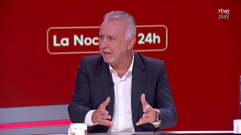 Xabier Fortes, presentador de "La Noche en 24h", gesticula en un estudio de televisi�n con fondo rojo y logos de RTVE.