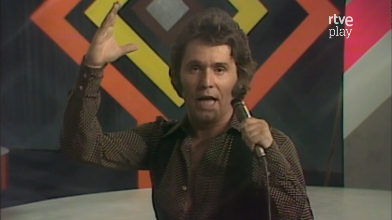 Primer plano de Raphael cantando con intensidad, micr�fono en mano y brazo alzado. Fondo geom�trico retro con logo "rtve play".