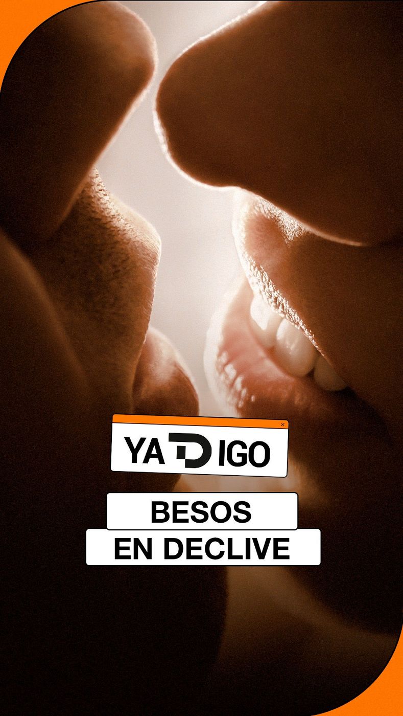 Primer plano de dos perfiles a punto de besarse, con iluminación cálida y el titular "BESOS EN DECLIVE" superpuesto.