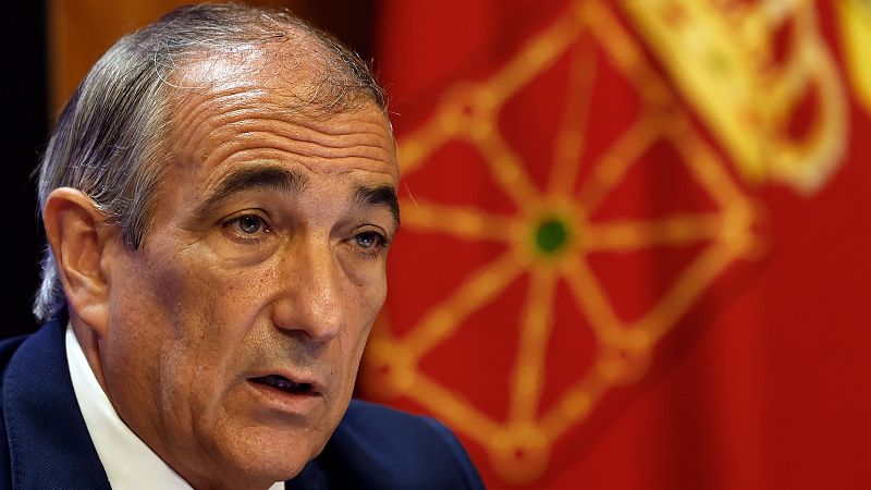 Óscar Chivite, consejero de Cohesión Territorial del Gobierno de Navarra, en una rueda de prensa. Viste traje azul oscuro y camisa blanca, con el escudo de Navarra al fondo.