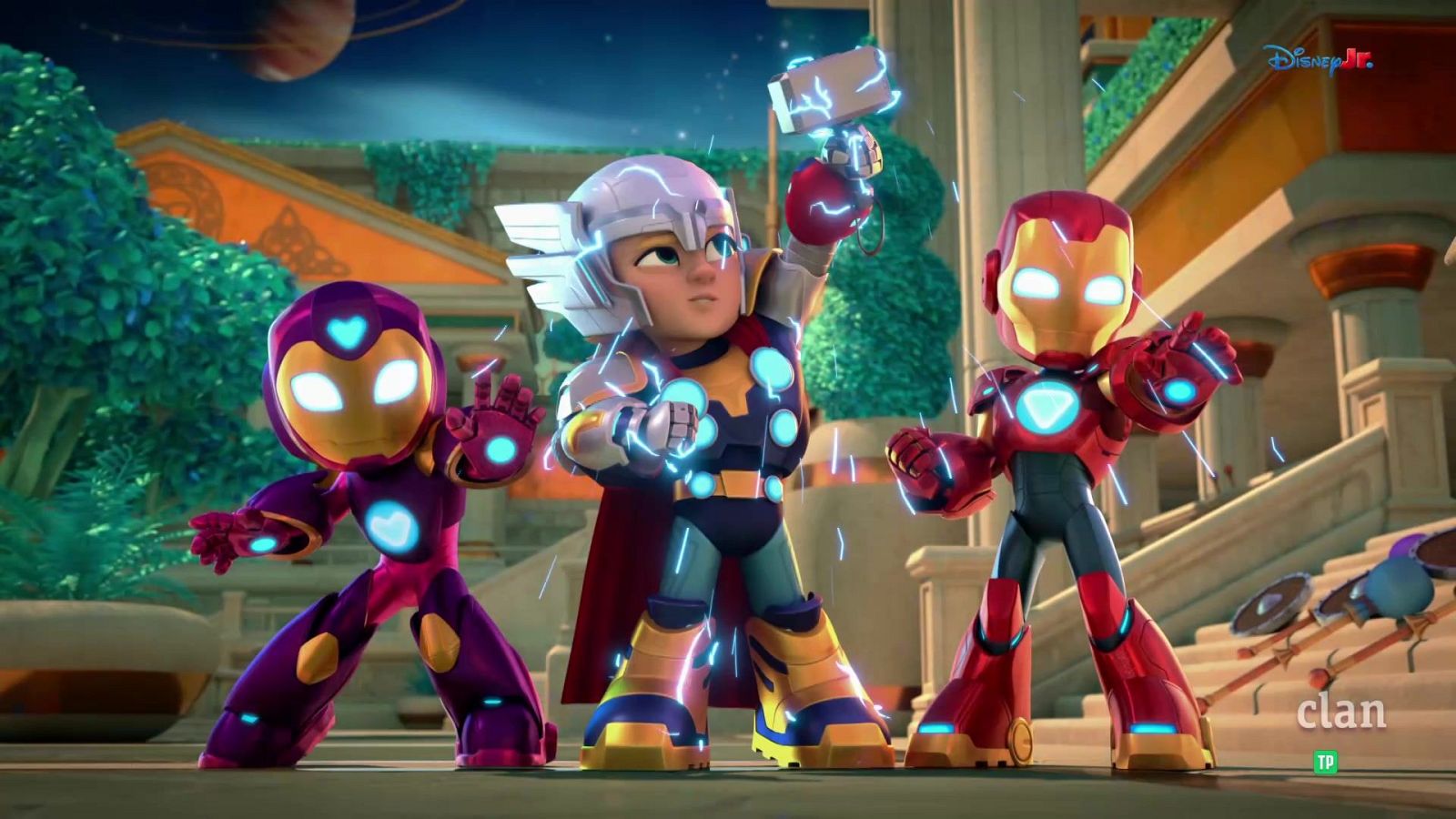Tres superhéroes infantiles, Thor, Iron Man y uno de armadura púrpura, en poses de acción con energía luminosa. Fondo arquitectónico, cielo nocturno con planeta anillado. Logotipos "Disney Jr." y "clan" visibles.