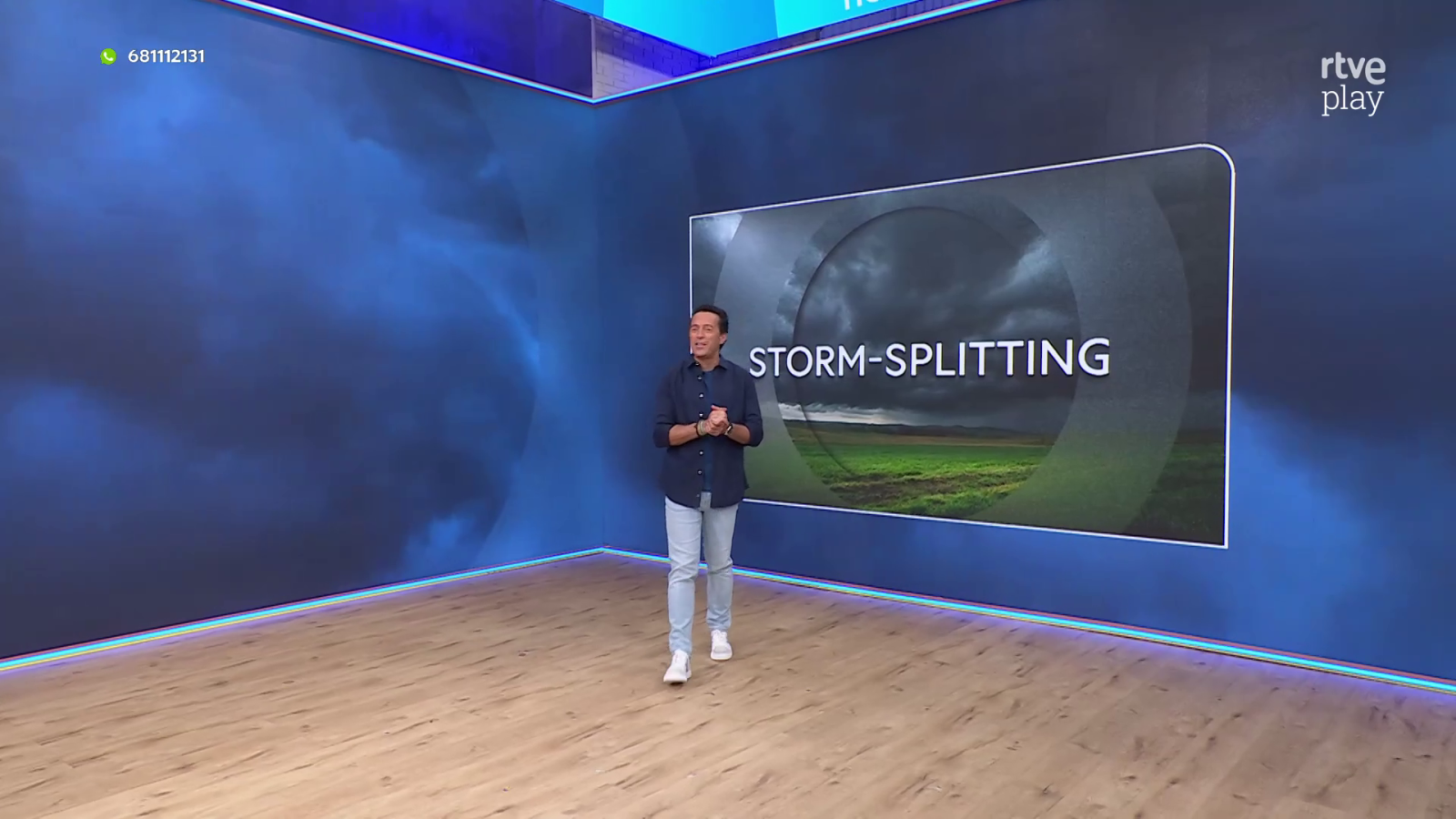 Roberto Brasero en estudio de RTVE Play presentando "Aquí la Tierra" sobre el fenómeno "STORM-SPLITTING", con cielo nublado en pantalla.