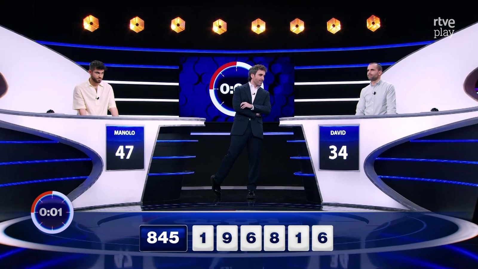 Plató de "Cifras y letras" con Aitor Albizua, Manolo (47 puntos) y David (34 puntos). Pantalla con temporizador a 0:01, números del juego y logo de rtve play.