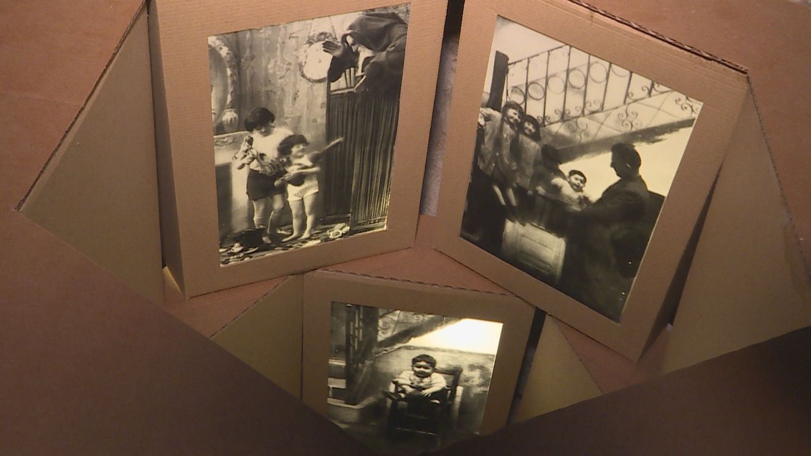 Tres fotografías antiguas en blanco y negro, una con dos niños y una figura adulta, otra con un grupo de personas y un hombre sentado, y un retrato de un niño en una mecedora, dentro de una caja.