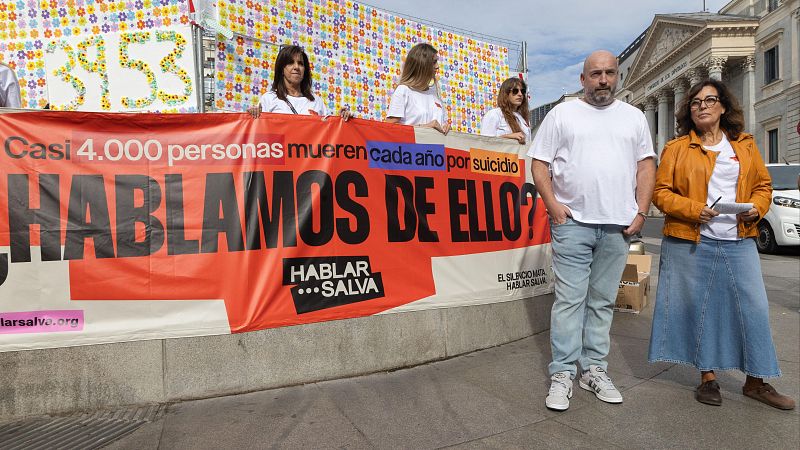 José Manuel López y Vicky Nieto, familiares de víctimas de suicidio, participan en la colocación de 3.953 flores en recuerdo de las personas fallecidas por suicidio, frente al Congreso