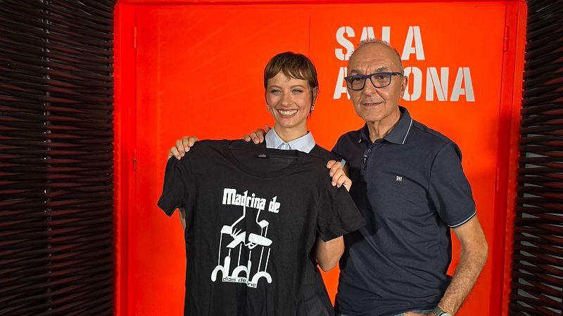 Elena Rivera y Gerardo Sánchez celebran el nombramiento de Rivera como "Madrina de días de cine" frente a una pared naranja con "SALA ONA".