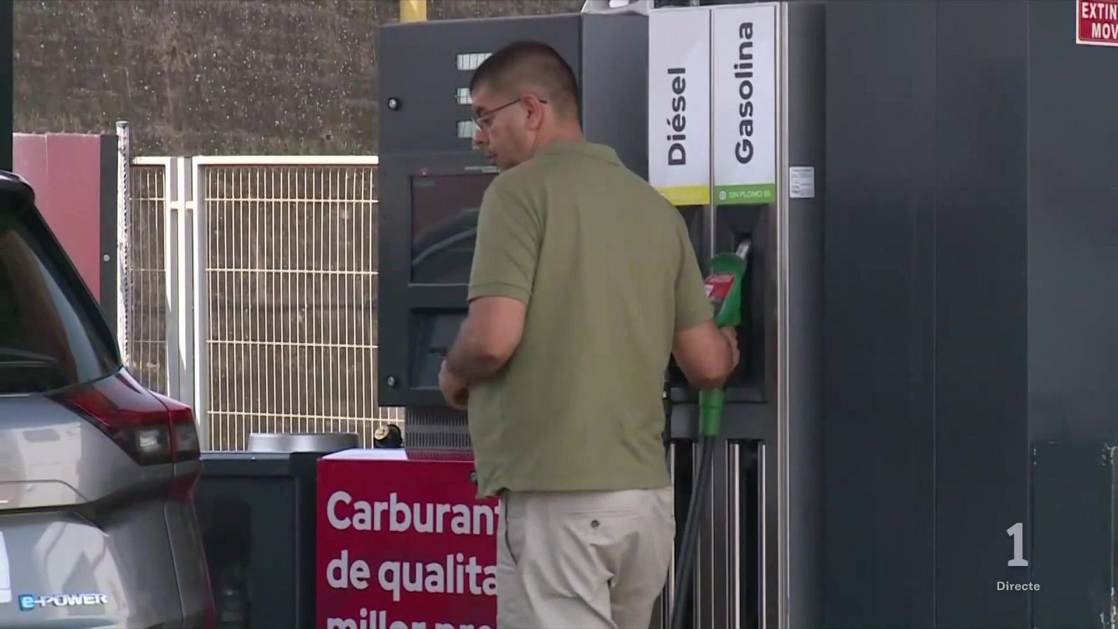 Hombre repostando gasolina en un coche SUV gris en una gasolinera. Se ve el cartel "Carburant de qualitat millor pre..." y la inscripción "e-POWER" en el vehículo.
