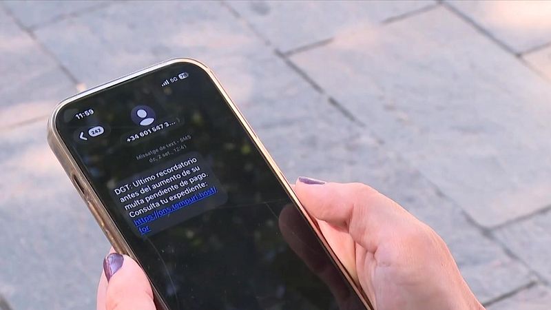 Mano con uñas moradas sostiene un smartphone mostrando un SMS de la DGT sobre una multa y un enlace sospechoso.