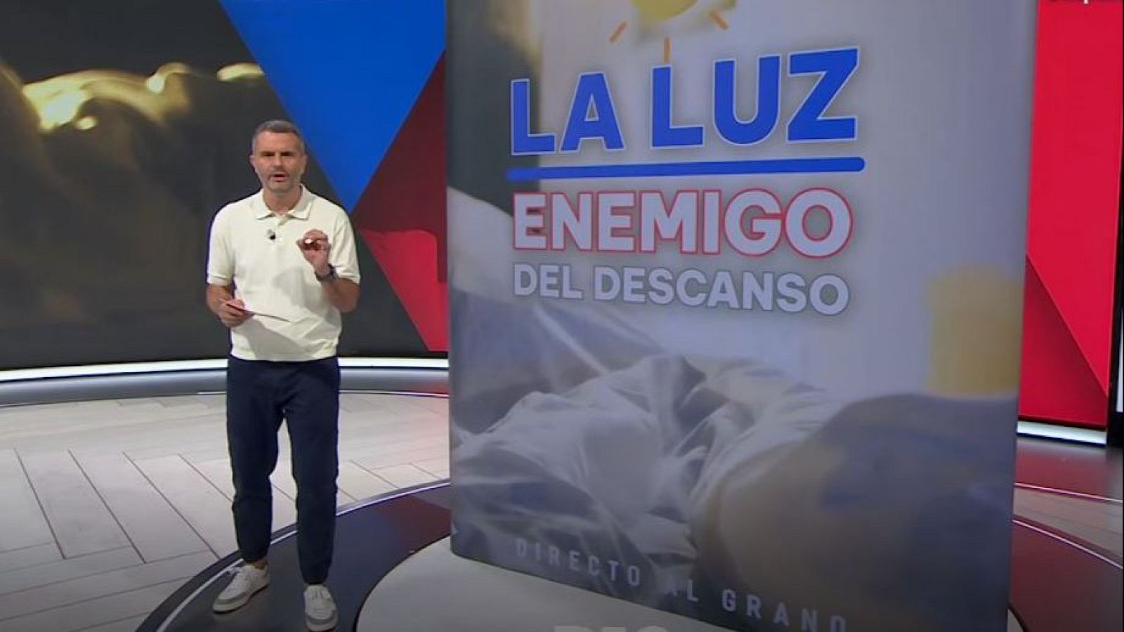 Presentador Juan Carlos en estudio moderno, con pantalla mostrando "LA LUZ ENEMIGO DEL DESCANSO" y "DIRECTO AL GRANO".