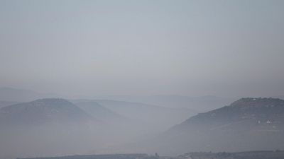 Paisaje monta�oso brumoso con colinas en primer plano y monta�as difuminadas al fondo. Atm�sfera serena y melanc�lica con tonos apagados.