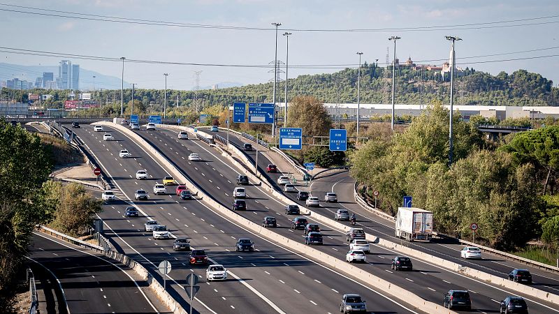 Vista aérea de autopista con tráfico denso, señales "M-50 Madrid" y "A-4 Córdoba", vegetación y silueta urbana. Carretera A4, cerca de Pinto (Madrid).