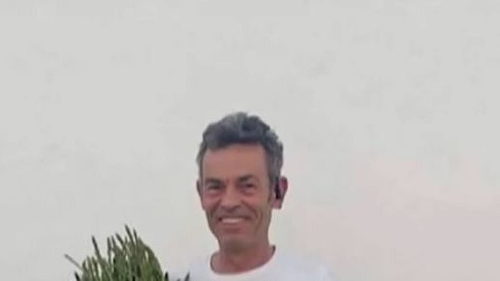 Retrato de Braulio Gómez, periodista español, sonriendo a cámara y sosteniendo hierbas verdes. Fondo liso y claro.